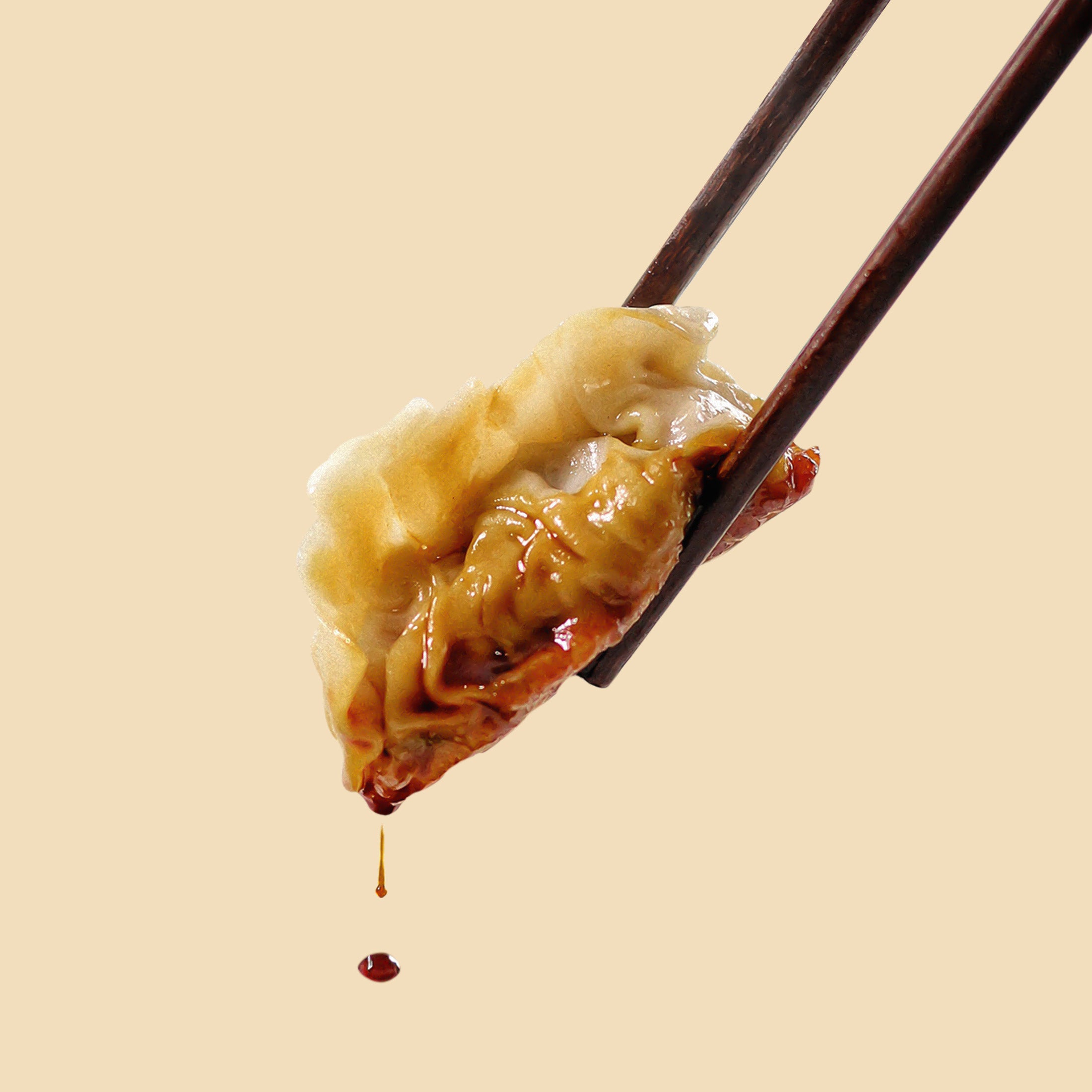 Dumpling with soy sauce holded with chopsticks