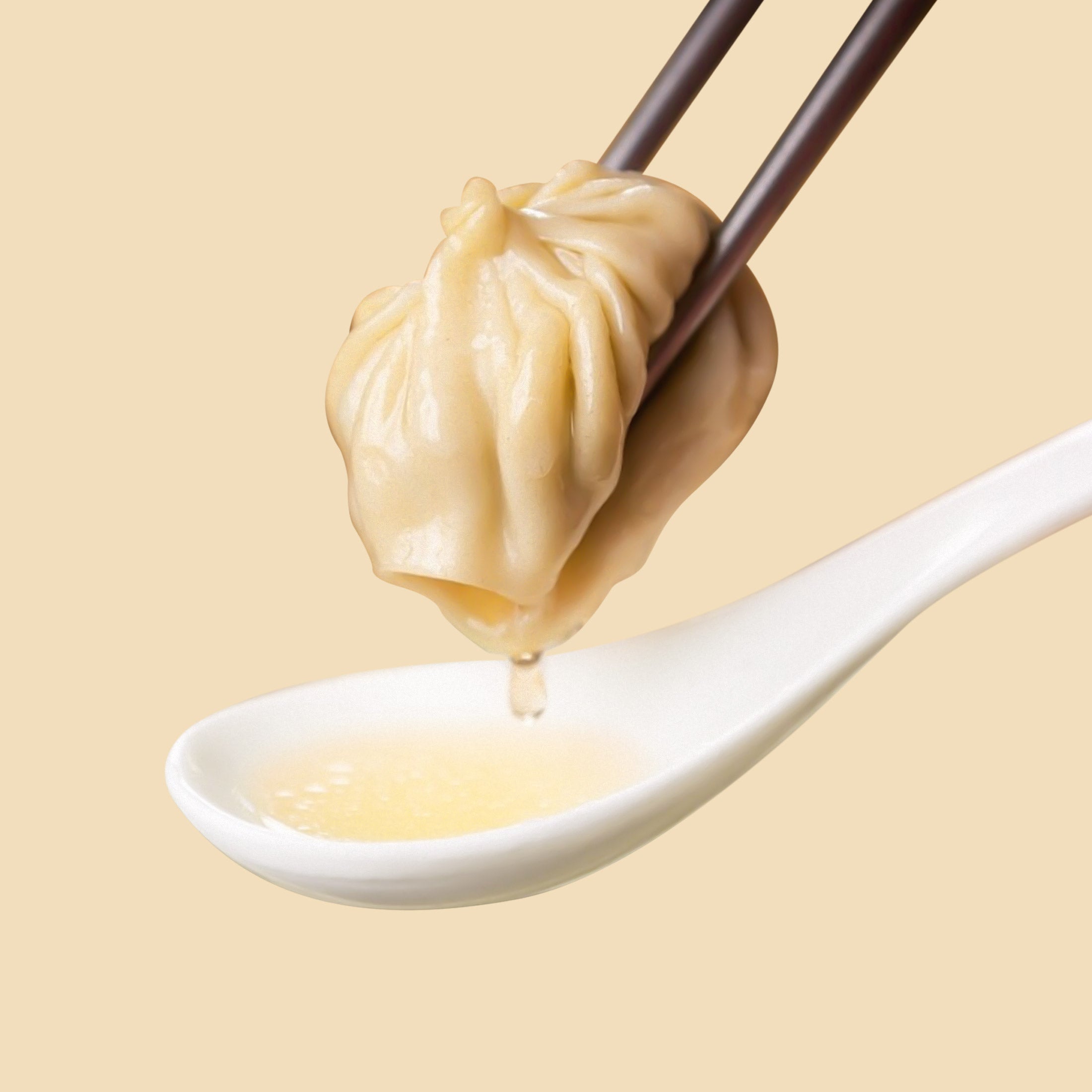 Soup dumpling holded with chopsticks on a spoon